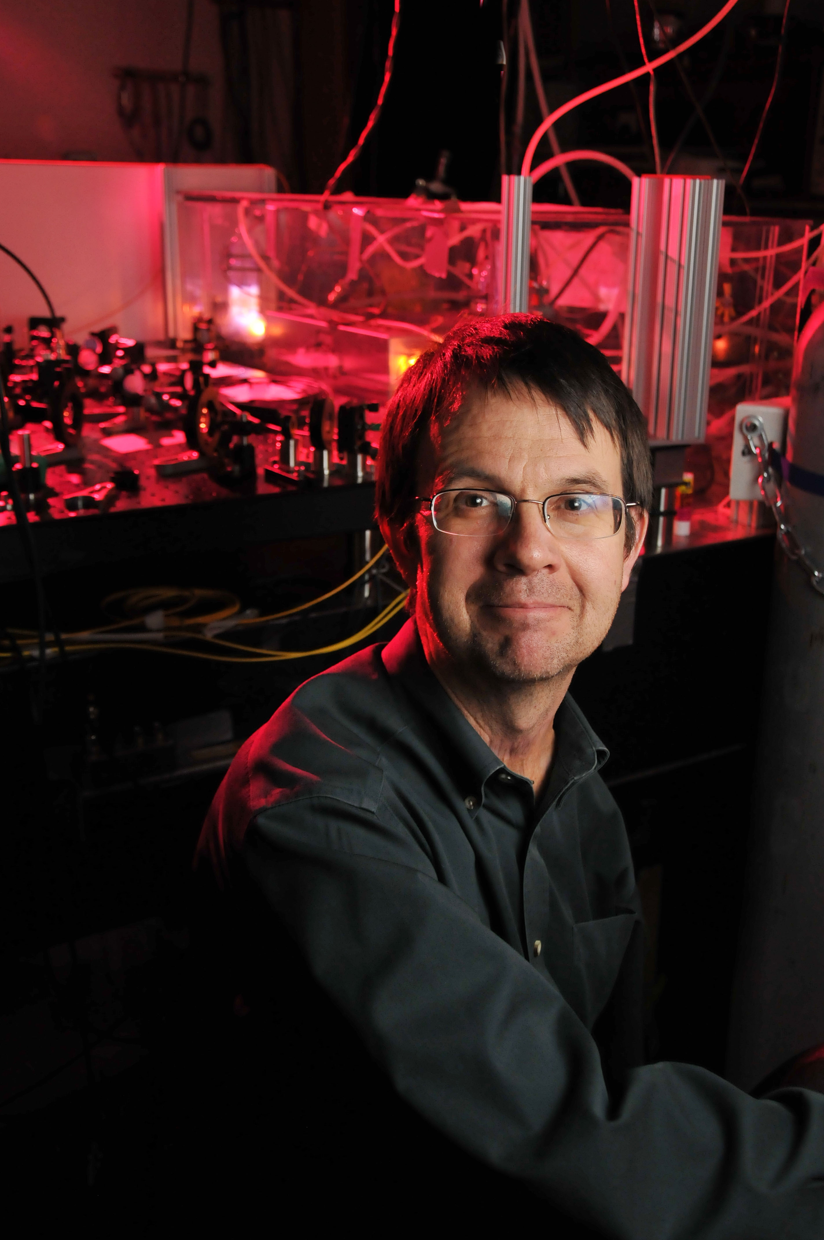 Man wearing glsses stnding in front of laser lab