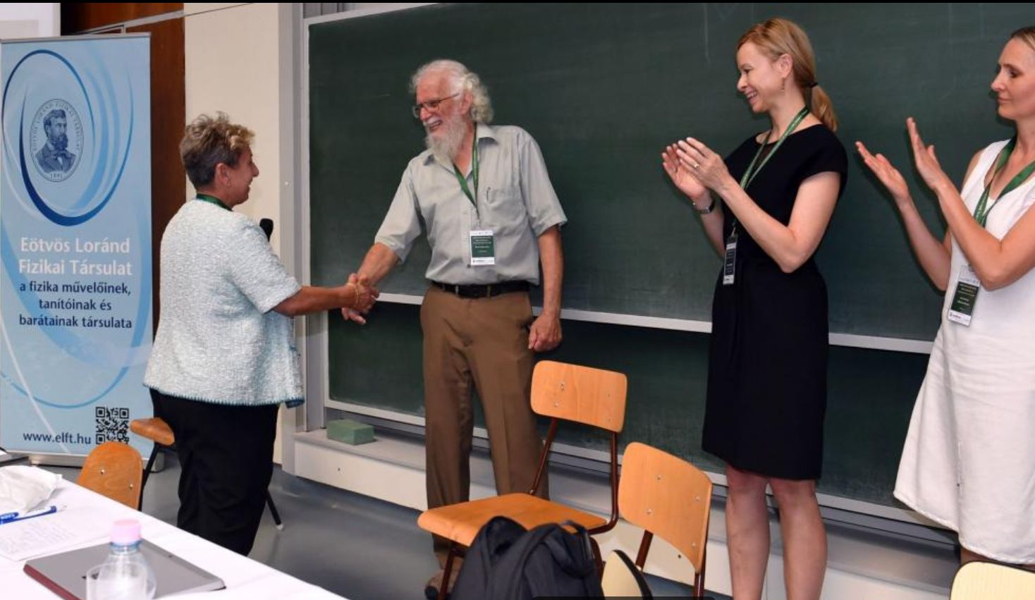 Dr. Marisa Michelini, president of GIREP and a professor at the University of Udine, Italy, congratulates Dr. Dean Zollman. Looking on are Dr. Claudia Haagen-Schuetzenhoefer, vice president of GIREP and a professor at University of Graz, Austria, and Dagmara Sokolowska, secretary of GIREP and an associate professor at Jagiellonian University, Poland.
